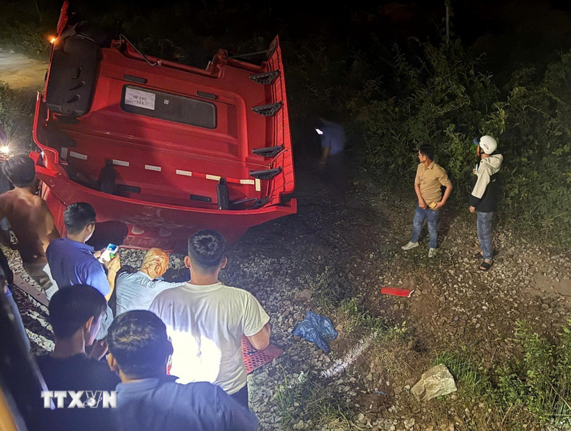 Phần đầu xe tải văng sang một bên đường ray, lật ngửa, biến dạng.