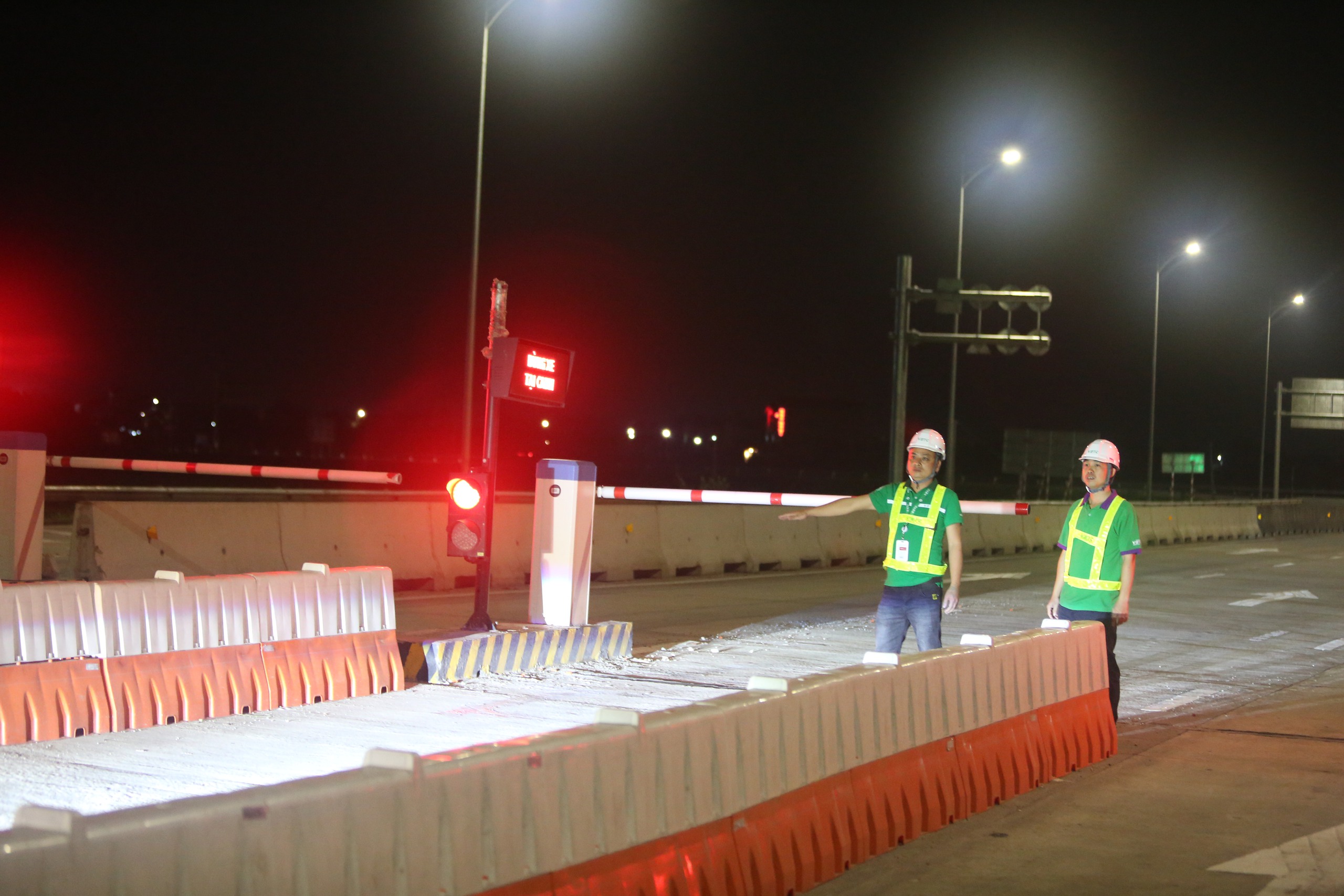 Tại nút giao Đông Xuân, nhân viên trực trạm ra hiệu lệnh cho các xe giảm tốc độ và nhắc nhở đối với các tài xế về việc thu phí cao tốc kể từ 22h ngày 2:3